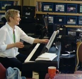 Photo of Lisa St. Clair adjusting sheet music on a keyboard