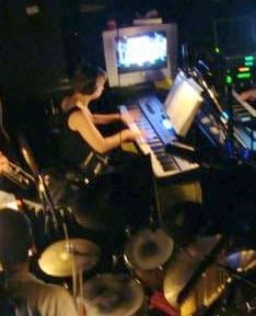 Photo of Lisa St. Clair playing keyboard in a pit